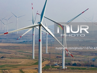 Giant windmills are spinning in the wind at Baoshan Town wind farm in the West Coast New Area of Qingdao, Shandong Province, China, on March...