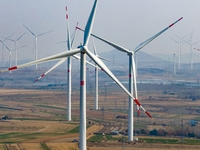 Giant windmills are spinning in the wind at Baoshan Town wind farm in the West Coast New Area of Qingdao, Shandong Province, China, on March...