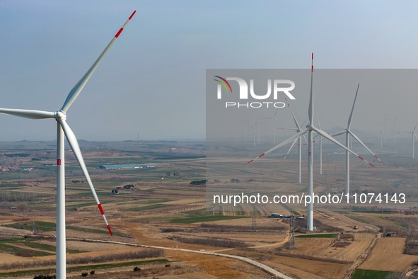 Giant windmills are spinning in the wind at Baoshan Town wind farm in the West Coast New Area of Qingdao, Shandong Province, China, on March...