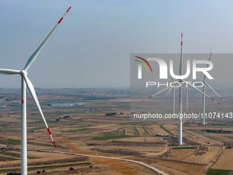 Giant windmills are spinning in the wind at Baoshan Town wind farm in the West Coast New Area of Qingdao, Shandong Province, China, on March...