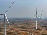 Giant windmills are spinning in the wind at Baoshan Town wind farm in the West Coast New Area of Qingdao, Shandong Province, China, on March...