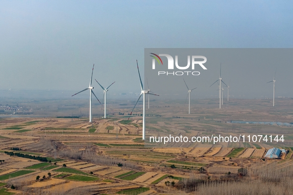 Giant windmills are spinning in the wind at Baoshan Town wind farm in the West Coast New Area of Qingdao, Shandong Province, China, on March...