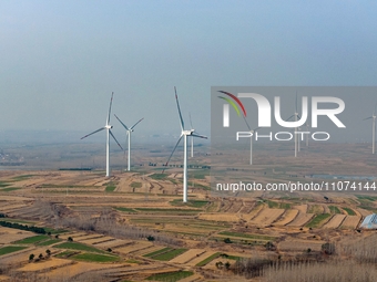 Giant windmills are spinning in the wind at Baoshan Town wind farm in the West Coast New Area of Qingdao, Shandong Province, China, on March...