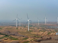 Giant windmills are spinning in the wind at Baoshan Town wind farm in the West Coast New Area of Qingdao, Shandong Province, China, on March...