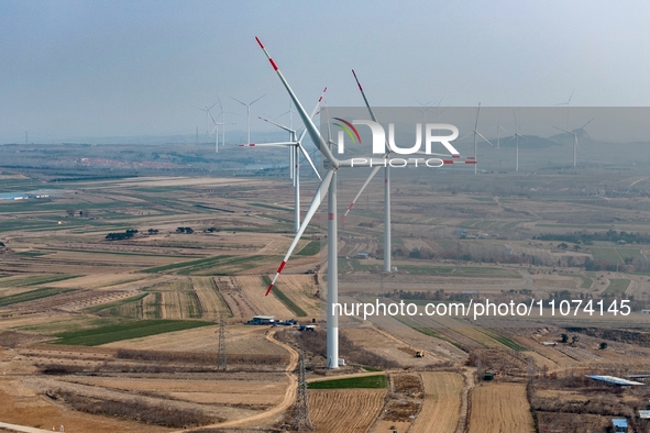 Giant windmills are spinning in the wind at Baoshan Town wind farm in the West Coast New Area of Qingdao, Shandong Province, China, on March...