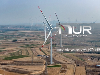 Giant windmills are spinning in the wind at Baoshan Town wind farm in the West Coast New Area of Qingdao, Shandong Province, China, on March...