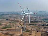 Giant windmills are spinning in the wind at Baoshan Town wind farm in the West Coast New Area of Qingdao, Shandong Province, China, on March...