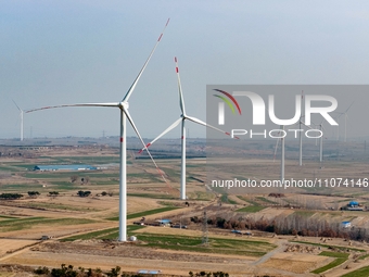 Giant windmills are spinning in the wind at Baoshan Town wind farm in the West Coast New Area of Qingdao, Shandong Province, China, on March...