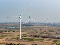 Giant windmills are spinning in the wind at Baoshan Town wind farm in the West Coast New Area of Qingdao, Shandong Province, China, on March...