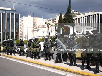 Police is standing in front of the parliament building while demonstrators attend a protest held by 
student associations and educational u...