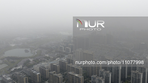 City buildings are looming under smog in Xi'an, Shaanxi Province, China, on March 16, 2024. 