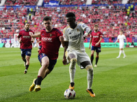 Vinicius Junior left winger of Real Madrid and Brazil and Ruben Garcia left winger of Osasuna and Spain compete for the ball during the LaLi...