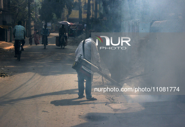 A municipal worker is fumigating a residential area to prevent the spread of diseases carried by mosquitoes and fleas in Siliguri, India, on...