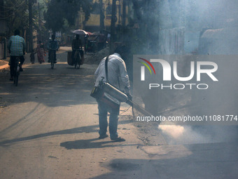 A municipal worker is fumigating a residential area to prevent the spread of diseases carried by mosquitoes and fleas in Siliguri, India, on...