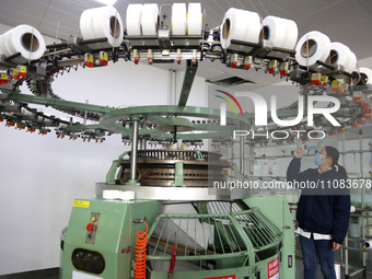 A worker is producing textile foreign trade products on a workshop production line at a spandex company workshop in the Lianyungang Economic...