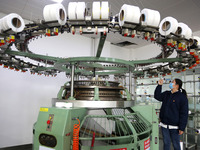 A worker is producing textile foreign trade products on a workshop production line at a spandex company workshop in the Lianyungang Economic...