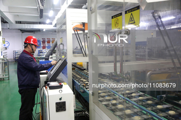 A worker is producing textile foreign trade products on a workshop production line at a spandex company workshop in the Lianyungang Economic...