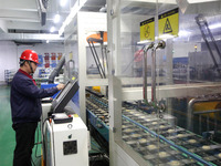 A worker is producing textile foreign trade products on a workshop production line at a spandex company workshop in the Lianyungang Economic...