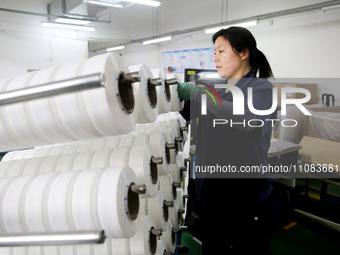 A worker is producing textile foreign trade products on a workshop production line at a spandex company workshop in the Lianyungang Economic...