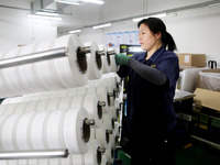 A worker is producing textile foreign trade products on a workshop production line at a spandex company workshop in the Lianyungang Economic...