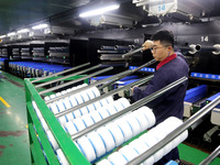 A worker is producing textile foreign trade products on a workshop production line at a spandex company workshop in the Lianyungang Economic...