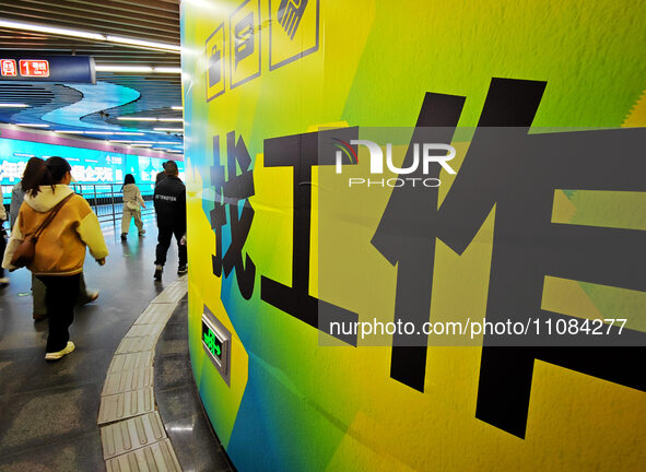 Passengers are walking past a light box advertising ''looking for jobs'' at Dawanglu Metro station in Beijing, China, on March 17, 2024. 