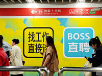 Passengers are walking past a light box advertising ''looking for jobs'' at Dawanglu Metro station in Beijing, China, on March 17, 2024. (