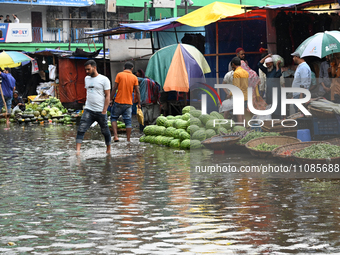 A vegetable vendor is waiting for customers in a waterlogged market at Karwan Bazar in Dhaka, Bangladesh, on March 19, 2024, after heavy mon...