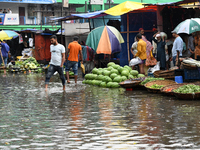 A vegetable vendor is waiting for customers in a waterlogged market at Karwan Bazar in Dhaka, Bangladesh, on March 19, 2024, after heavy mon...