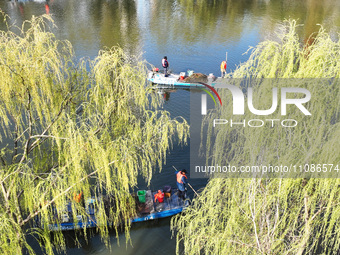 Cleaners are cleaning garbage on the Bian River to mark the upcoming World Water Day in Suqian, Jiangsu Province, China, on March 20, 2024....