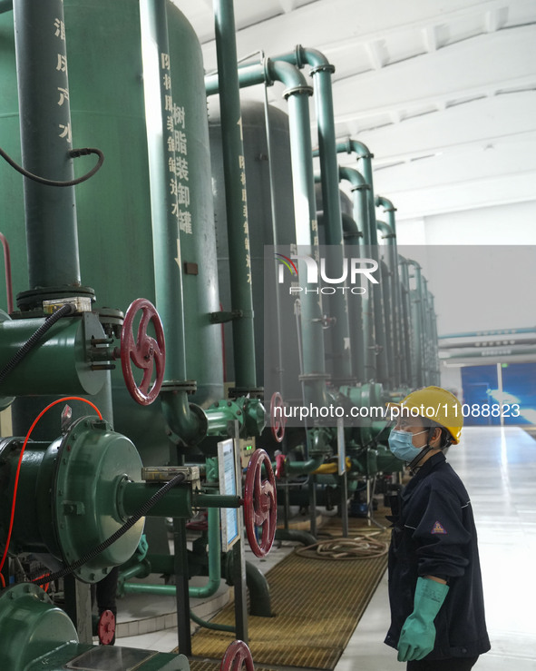 A power plant worker is checking the backwashing water of an ultrafiltration device in Zouping, Shandong Province, China, on March 21, 2024....