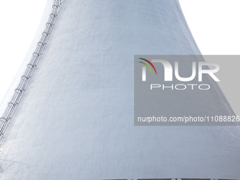 A power plant worker is walking by a cool water tower, which has achieved zero discharge of circulating water, in Zouping, Shandong province...