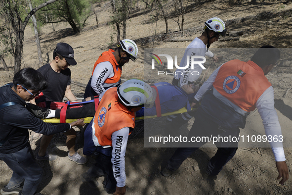 Members of Civil Protection are rescuing a person who suffered a fall while climbing Cerro de la Estrella in the Iztapalapa mayor's office i...