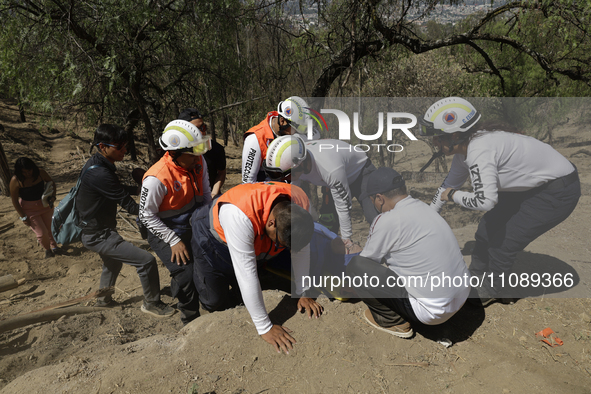 Members of Civil Protection are rescuing a person who suffered a fall while climbing Cerro de la Estrella in the Iztapalapa mayor's office i...