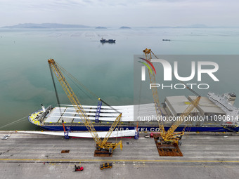 Border police are monitoring the hoisting of the world's longest 108-meter, 100-ton high-power wind turbine blades onto a cruise ship at Fuz...