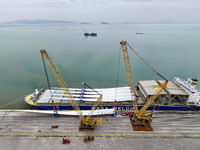 Border police are monitoring the hoisting of the world's longest 108-meter, 100-ton high-power wind turbine blades onto a cruise ship at Fuz...