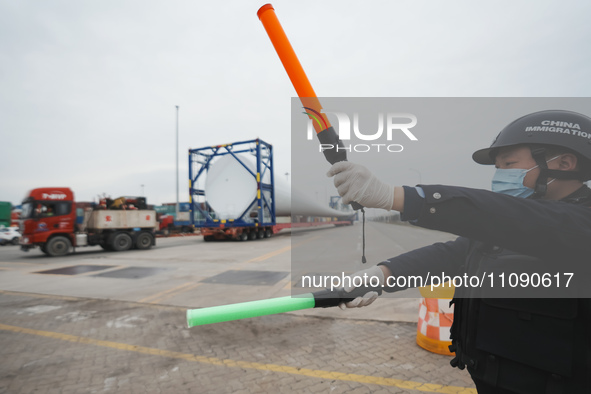 Police officers are guiding the loading of wind power blades at the port of Fuzhou, Fujian province, China, on March 23, 2024. 