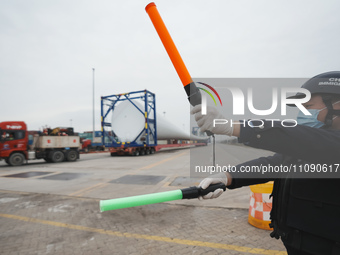 Police officers are guiding the loading of wind power blades at the port of Fuzhou, Fujian province, China, on March 23, 2024. (