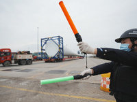 Police officers are guiding the loading of wind power blades at the port of Fuzhou, Fujian province, China, on March 23, 2024. (