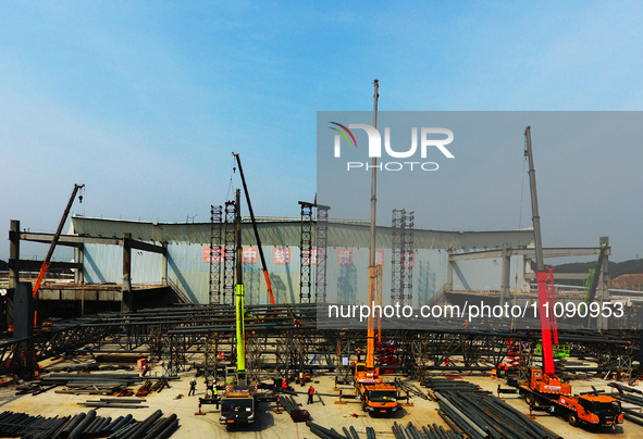 Construction workers are assembling steel structure roof trusses at the east station of Lushan Station of the Anjiu Section of the Beijing-H...