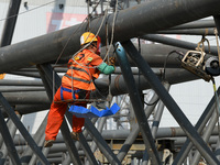 Construction workers are assembling steel structure roof trusses at the east station of Lushan Station of the Anjiu Section of the Beijing-H...