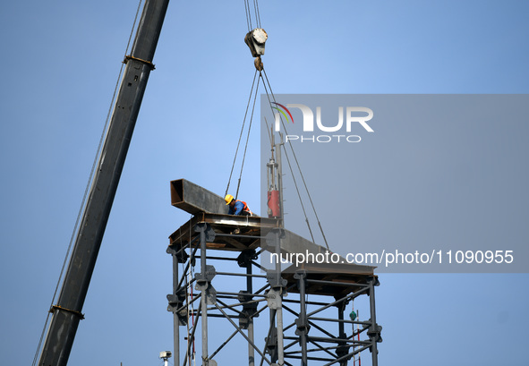 Construction workers are assembling steel structure roof trusses at the east station of Lushan Station of the Anjiu Section of the Beijing-H...