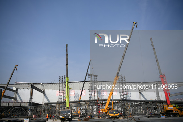 Construction workers are assembling steel structure roof trusses at the east station of Lushan Station of the Anjiu Section of the Beijing-H...