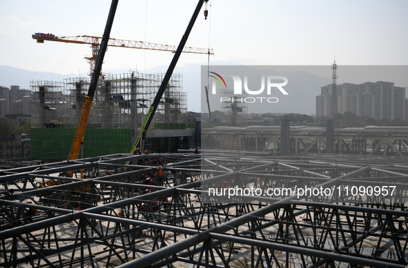 Construction workers are assembling steel structure roof trusses at the east station of Lushan Station of the Anjiu Section of the Beijing-H...