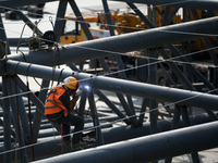 Construction workers are assembling steel structure roof trusses at the east station of Lushan Station of the Anjiu Section of the Beijing-H...