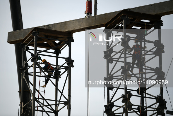 Construction workers are assembling steel structure roof trusses at the east station of Lushan Station of the Anjiu Section of the Beijing-H...