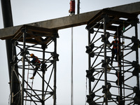 Construction workers are assembling steel structure roof trusses at the east station of Lushan Station of the Anjiu Section of the Beijing-H...