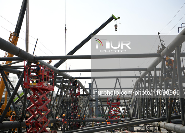 Construction workers are assembling steel structure roof trusses at the east station of Lushan Station of the Anjiu Section of the Beijing-H...