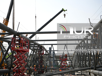 Construction workers are assembling steel structure roof trusses at the east station of Lushan Station of the Anjiu Section of the Beijing-H...