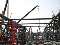 Construction workers are assembling steel structure roof trusses at the east station of Lushan Station of the Anjiu Section of the Beijing-H...